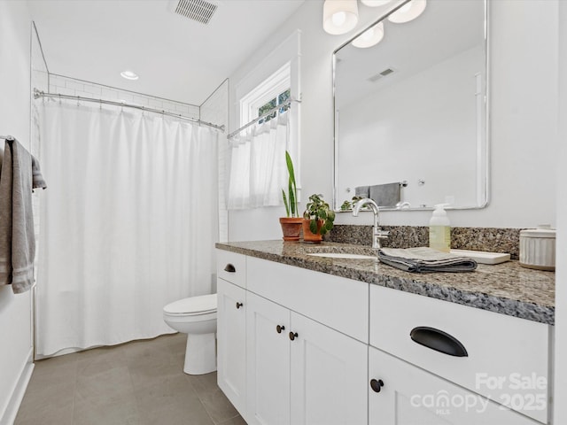 bathroom with tile patterned flooring, vanity, and toilet