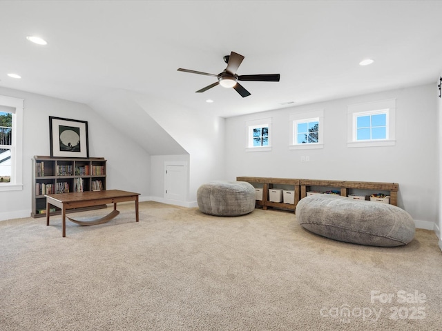 sitting room featuring ceiling fan, carpet floors, and vaulted ceiling