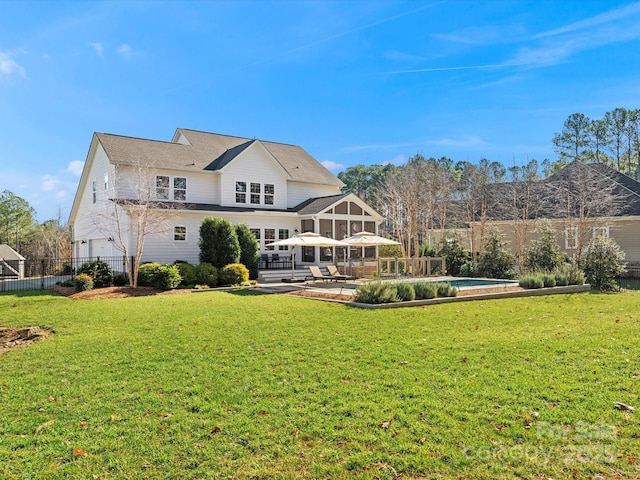 rear view of house featuring a yard and a fenced in pool