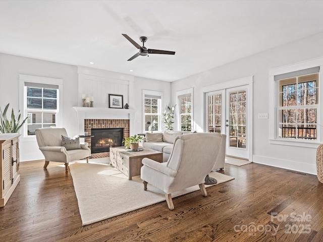 living room featuring french doors, a brick fireplace, ceiling fan, and dark wood-type flooring