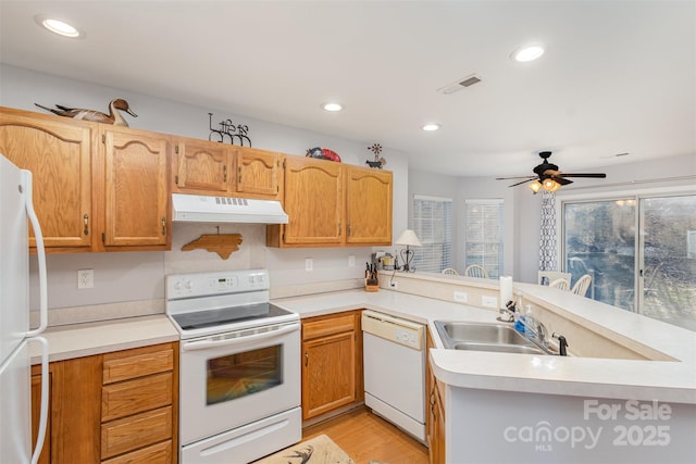 kitchen with sink, ceiling fan, kitchen peninsula, white appliances, and light hardwood / wood-style flooring