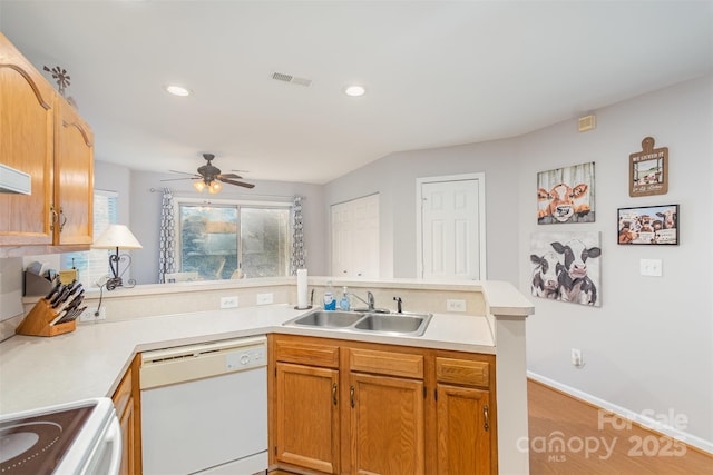 kitchen featuring white appliances, kitchen peninsula, sink, and a wealth of natural light