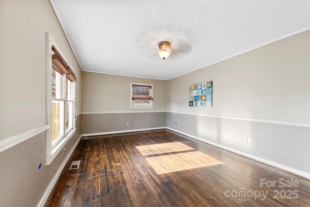 unfurnished room featuring dark hardwood / wood-style flooring and a textured ceiling