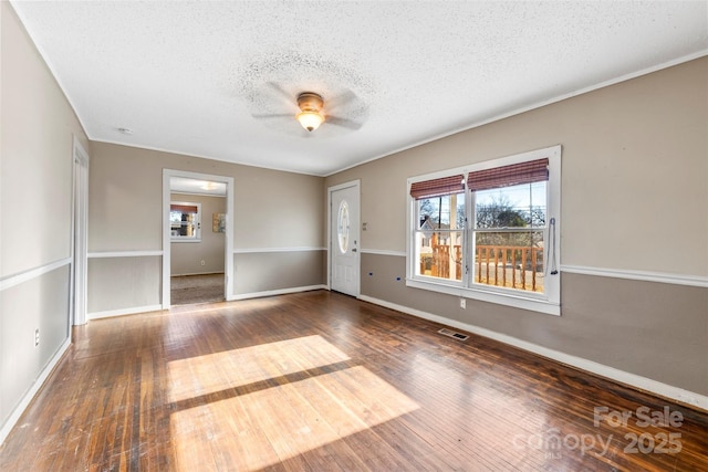 empty room featuring a textured ceiling, dark hardwood / wood-style flooring, and ceiling fan