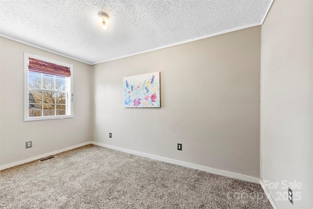 carpeted empty room with a textured ceiling