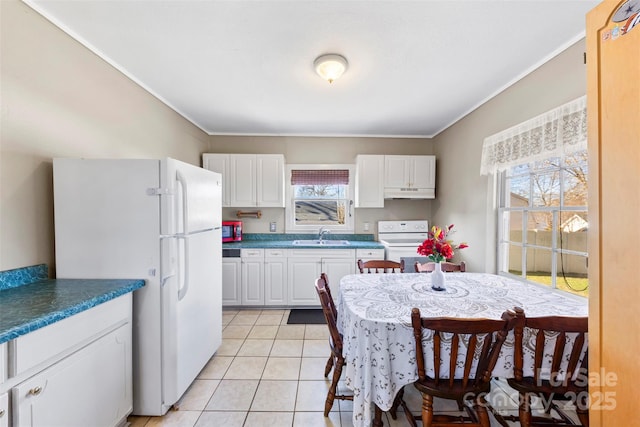 kitchen with white cabinets, light tile patterned floors, white appliances, and sink