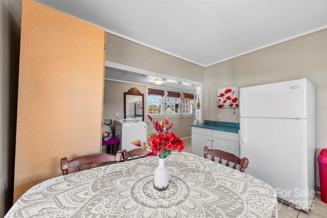 tiled dining room featuring washer / dryer