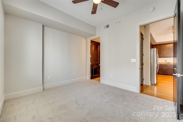 carpeted empty room featuring sink and ceiling fan