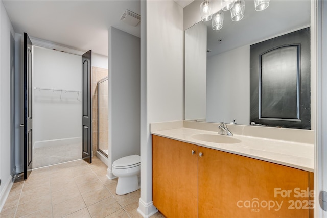 bathroom with vanity, a shower with shower door, tile patterned floors, and toilet