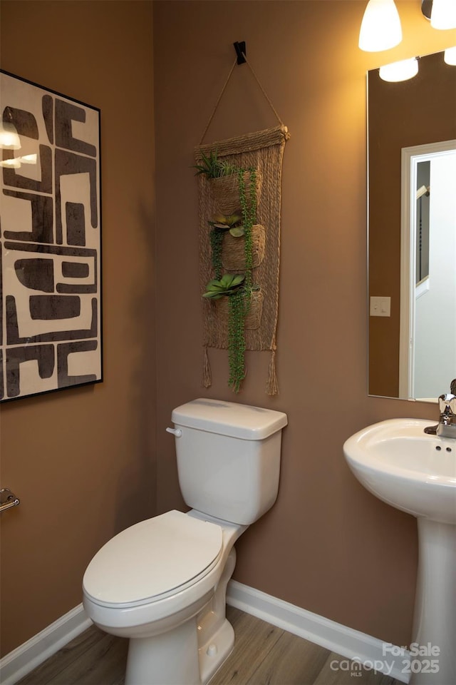 bathroom with hardwood / wood-style floors, toilet, and sink