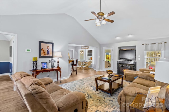 living room featuring vaulted ceiling, ceiling fan, and light wood-type flooring