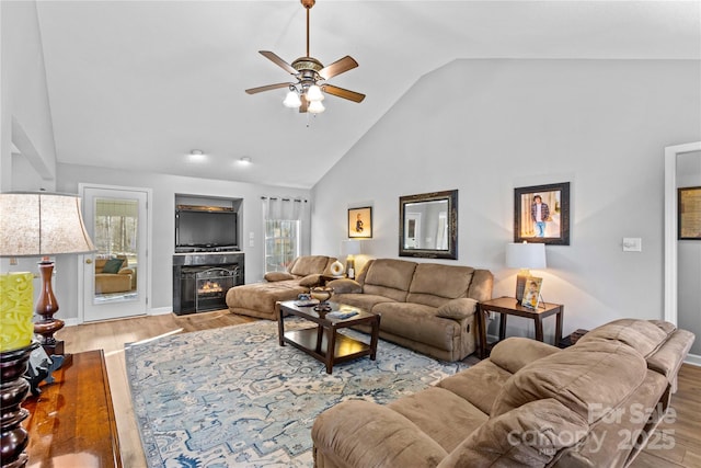 living room with high vaulted ceiling, light hardwood / wood-style floors, and ceiling fan