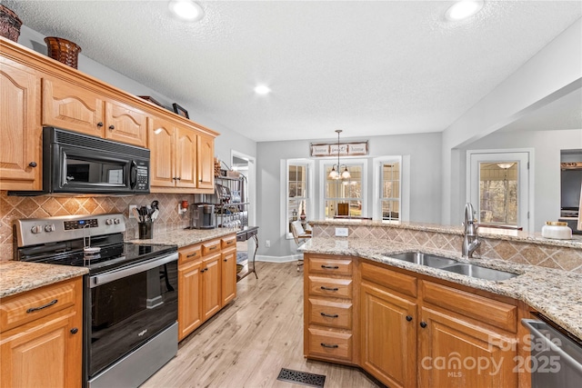 kitchen featuring appliances with stainless steel finishes, sink, backsplash, light hardwood / wood-style floors, and a textured ceiling