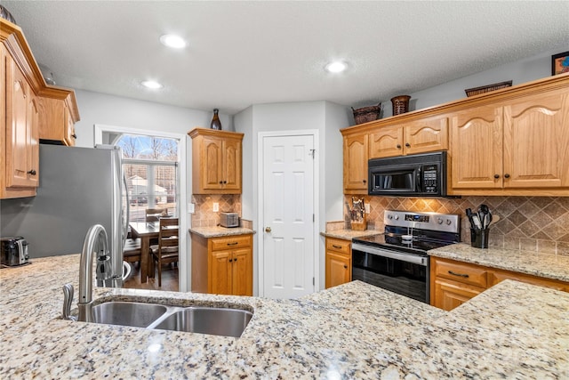 kitchen featuring stainless steel appliances, sink, and light stone counters