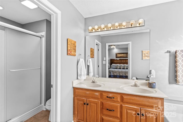 bathroom with tile patterned flooring, vanity, a textured ceiling, toilet, and walk in shower