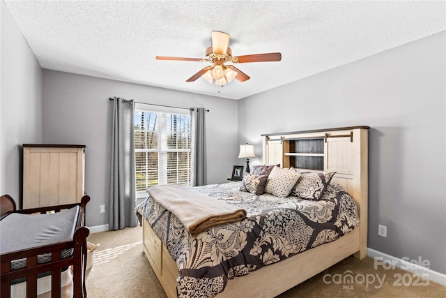 carpeted bedroom featuring ceiling fan and a textured ceiling