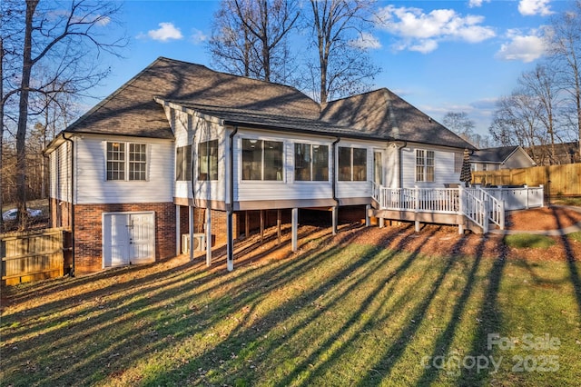 back of property with a yard and a deck