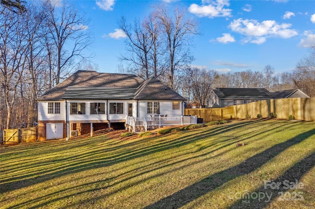 rear view of house with a deck and a lawn