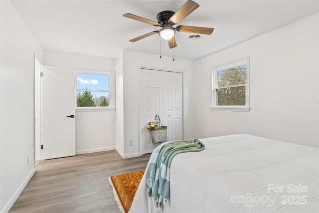 bedroom with a closet, ceiling fan, and light hardwood / wood-style flooring