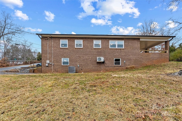 view of side of property featuring a lawn and central AC unit