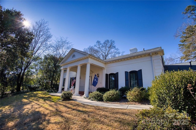 neoclassical home featuring covered porch and a front lawn