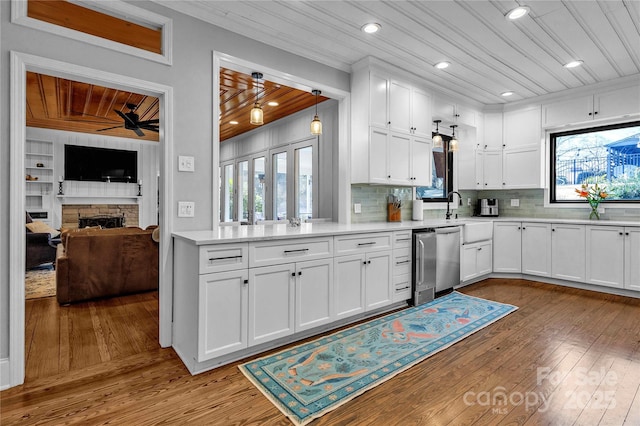 kitchen with white cabinets, ceiling fan, wooden ceiling, and a fireplace