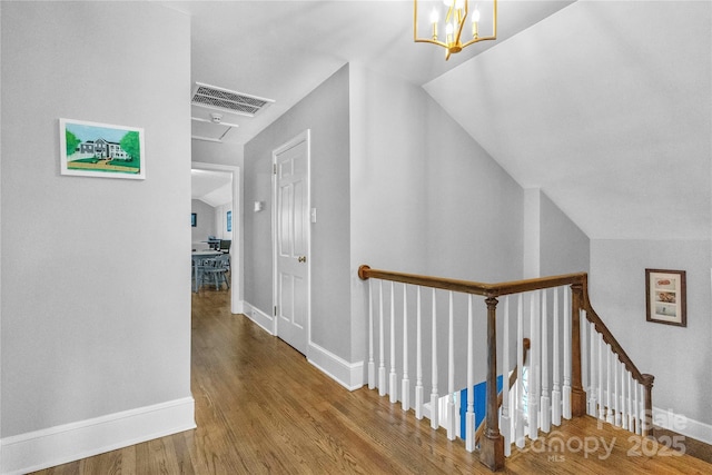 hall featuring a chandelier, lofted ceiling, and hardwood / wood-style flooring