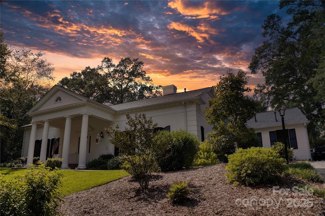 view of front of home with covered porch and a yard