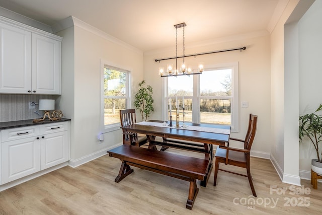 dining space featuring crown molding, a notable chandelier, and light wood-type flooring