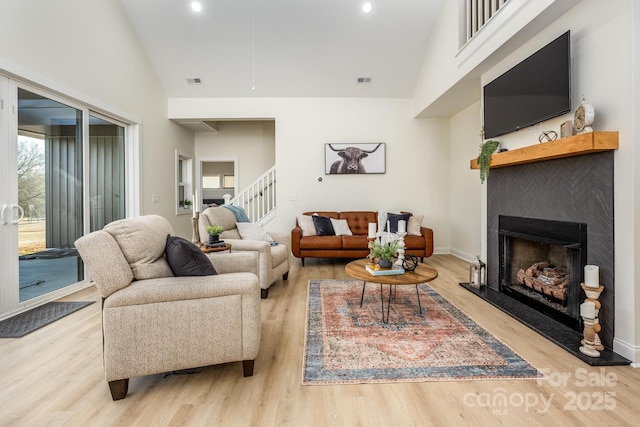 living room featuring high vaulted ceiling and light wood-type flooring