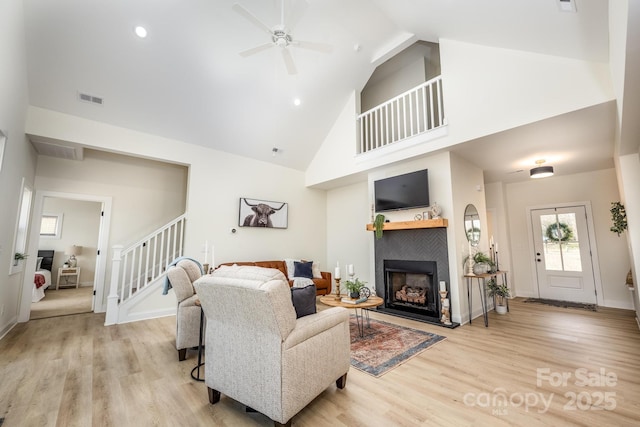 living room featuring ceiling fan, light wood-type flooring, and high vaulted ceiling