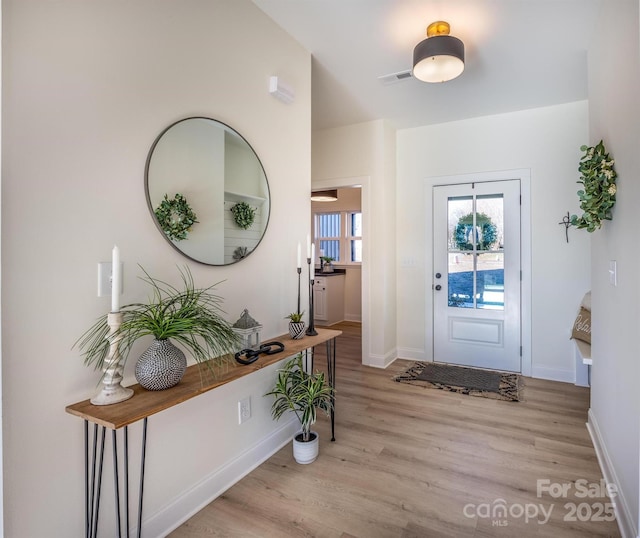 entrance foyer with visible vents, baseboards, and wood finished floors