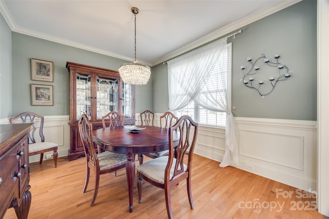 dining room with crown molding, light hardwood / wood-style floors, and a chandelier