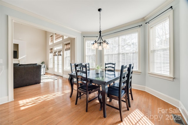 dining area with french doors, ornamental molding, a notable chandelier, and light hardwood / wood-style flooring