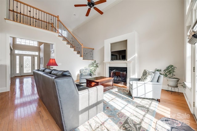 living room with ceiling fan, hardwood / wood-style floors, and a high ceiling