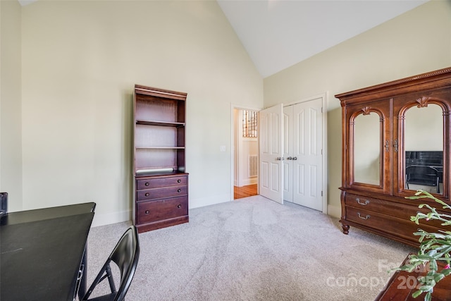 carpeted office space featuring high vaulted ceiling