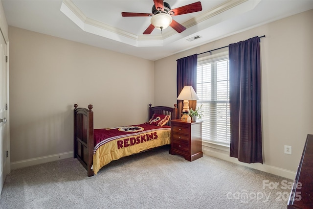 carpeted bedroom featuring crown molding, ceiling fan, and a tray ceiling