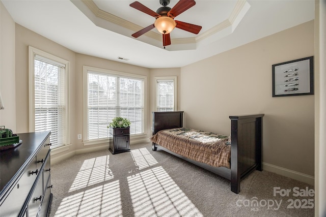 carpeted bedroom featuring crown molding, ceiling fan, and a raised ceiling