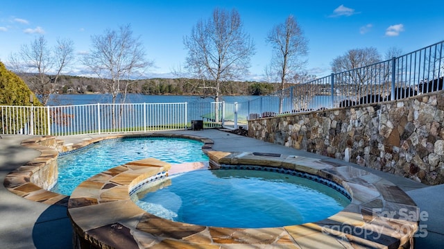 view of pool with a water view and an in ground hot tub