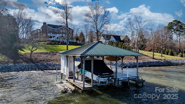 view of dock with a lawn and a water view