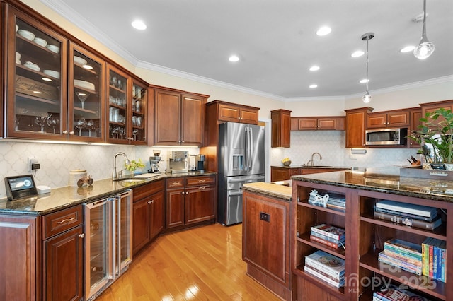 kitchen featuring sink, hanging light fixtures, tasteful backsplash, wine cooler, and appliances with stainless steel finishes