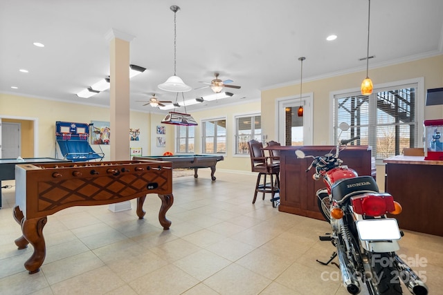 recreation room featuring a wealth of natural light, ornamental molding, and bar