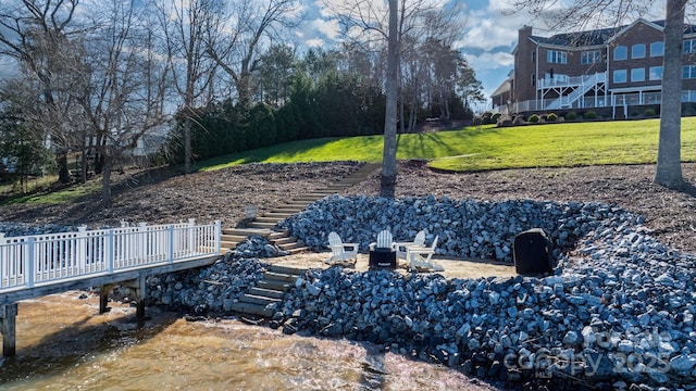 view of yard featuring a deck and an outdoor fire pit