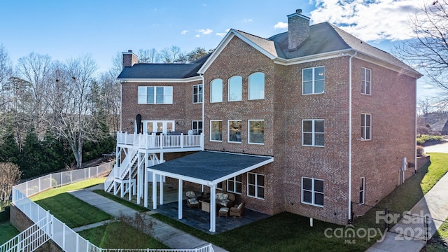 back of house featuring outdoor lounge area, a yard, and a patio area