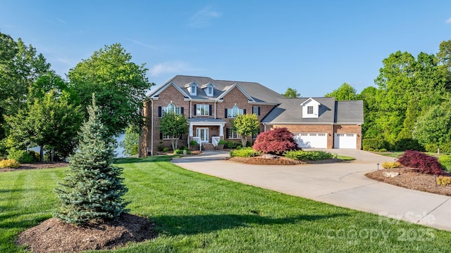 view of front of home featuring a garage, a front yard, driveway, and brick siding