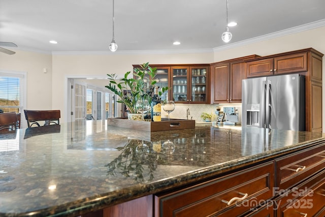 kitchen featuring stainless steel refrigerator with ice dispenser, decorative light fixtures, decorative backsplash, and ornamental molding