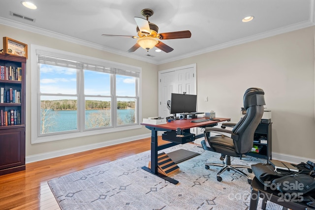 office space with ceiling fan, baseboards, light wood-type flooring, visible vents, and ornamental molding