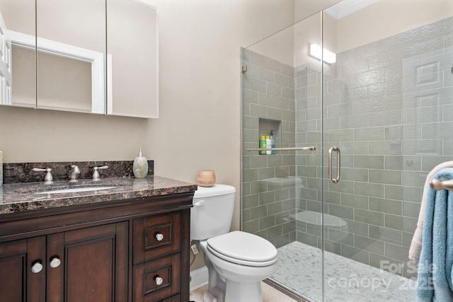 bathroom featuring vanity, a stall shower, and toilet