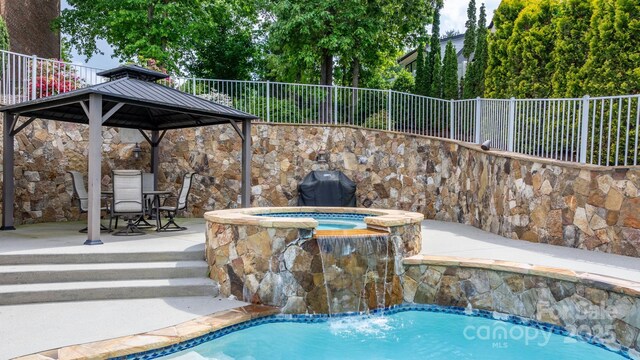 pool featuring a gazebo, fence, an in ground hot tub, and area for grilling