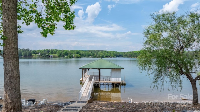 dock area with a gazebo, a view of trees, and a water view